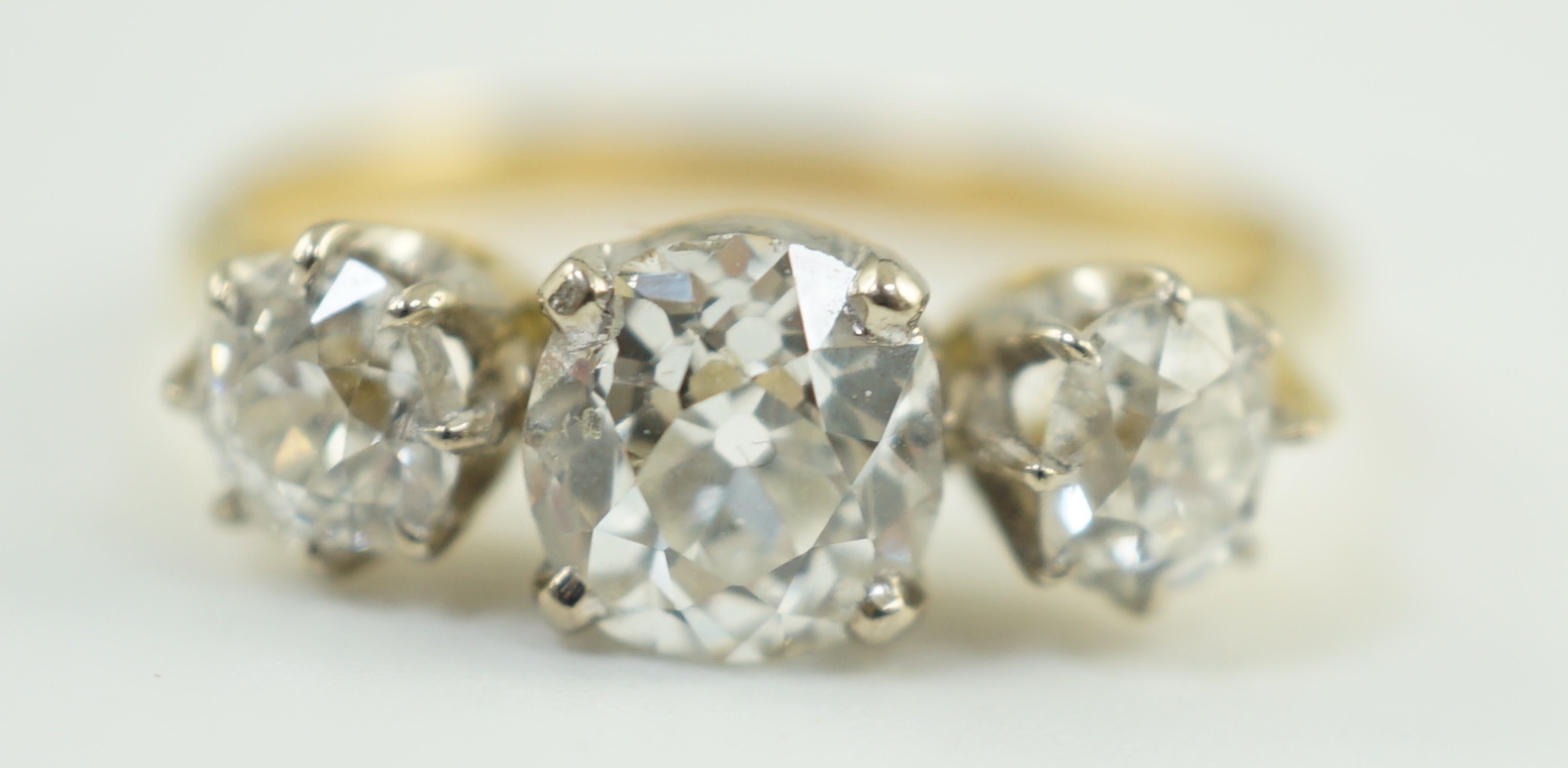 A modern 18ct gold and three stone diamond set ring